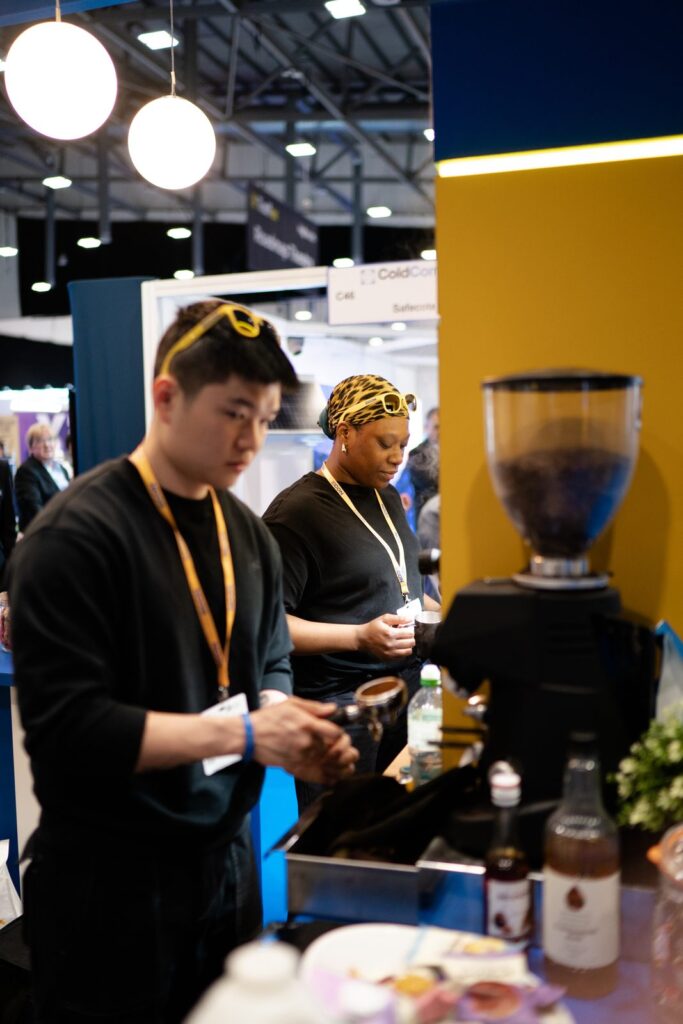 Tom’s Coffee baristas Kai and Fai preparing espresso on an exhibition stand
